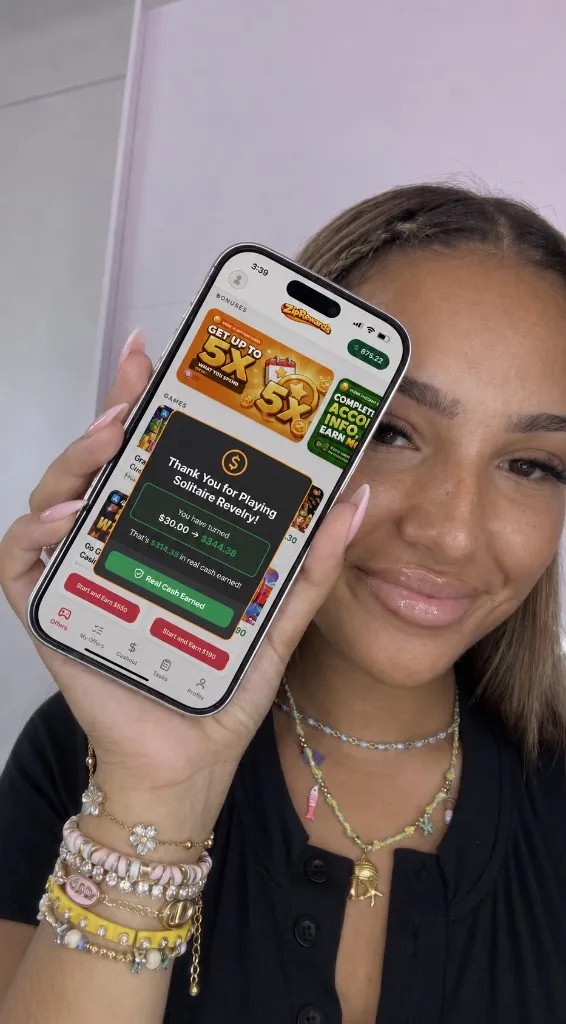 Player holding phone showing cash earned